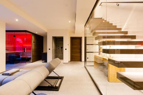 a living room with a couch and stairs at Dorfchalet das Luxus-Wellness-Chalet im Skigebiet in Grossarl