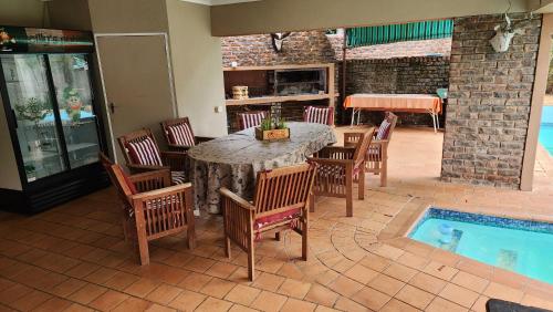 a patio with a table and chairs and a swimming pool at SABLE INN B&B in Modimolle