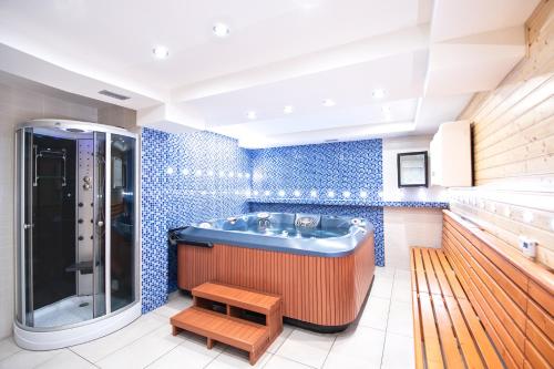 a bathroom with a tub and blue tiles at Penzion Avionika in Kovářská