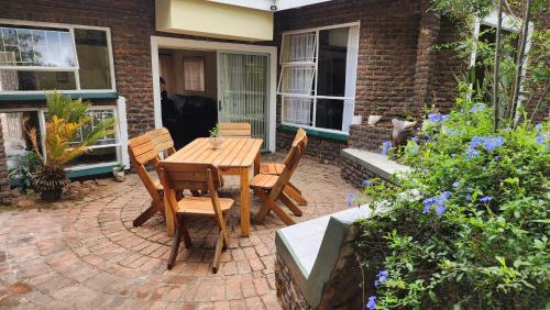 a wooden table and chairs on a brick patio at SABLE INN B&B in Modimolle
