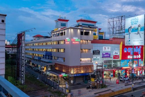 a building with neon signs on it in a city at Hotel Stay Bella Kozhikode in Kozhikode