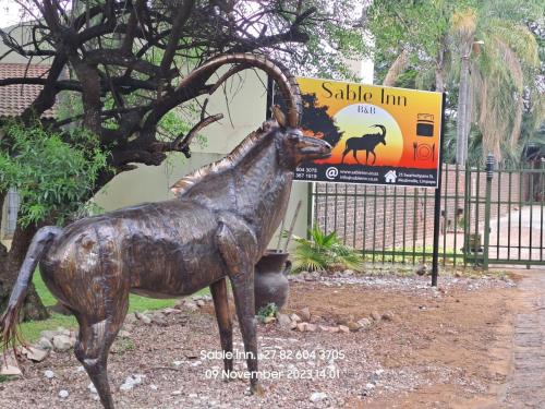 a statue of a horse in front of a fence at SABLE INN B&B in Modimolle