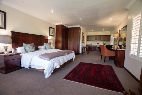 a bedroom with a large bed and a kitchen at Little Tuscany Boutique Hotel in Johannesburg