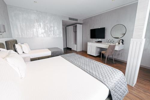 een hotelkamer met een wit bed en een bureau bij Royal G Max in Golem