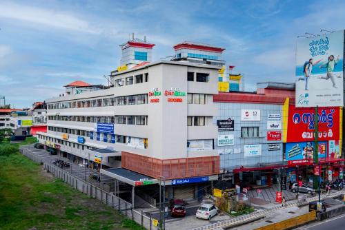 a white building with a lot of signs on it at Hotel Stay Bella Kozhikode in Kozhikode