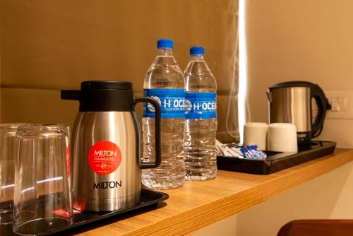 a coffee maker and two bottles of water on a counter at Hotel Stay Bella Kozhikode in Kozhikode