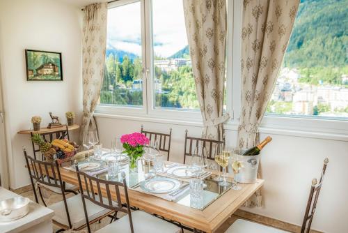 a dining room with a table and chairs and a window at Panorama Spa Lodges DAS.SCHILLER in Bad Gastein