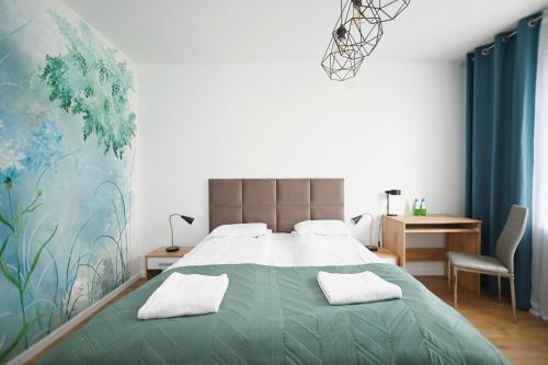 - une chambre avec un grand lit et une couverture verte dans l'établissement Victus Apartamenty, Apartament Rey, à Sopot