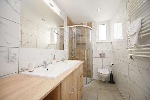 La salle de bains est pourvue d'un lavabo, d'une douche et de toilettes. dans l'établissement Victus Apartamenty, Apartament Rey, à Sopot