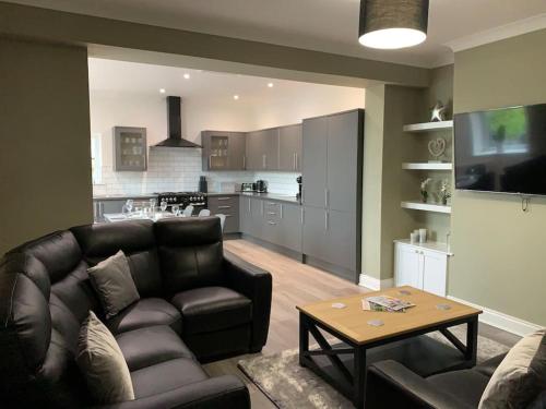 a living room with a couch and a table and a kitchen at Church View in York