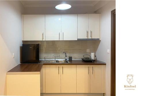 una cocina con armarios blancos y fregadero en Design downtown suite (K2), en Larisa