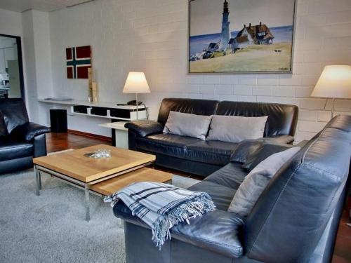 a living room with leather couches and a coffee table at Ferienhaus-Christel in Langeoog
