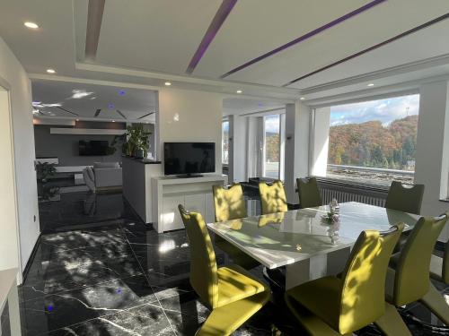 a dining room with a table and yellow chairs at Hamdanes Apartment in Sundern