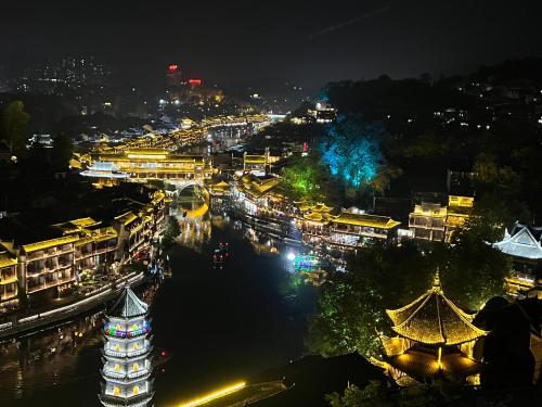 a view of a city at night at Phoenix Best River View B&B in Fenghuang