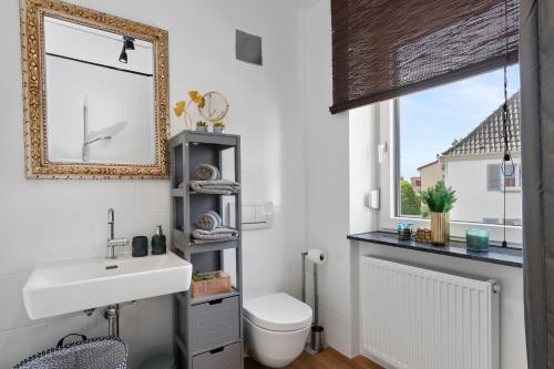 a bathroom with a sink and a mirror and a toilet at ANYTIME - Apartments in Langenargen in Langenargen