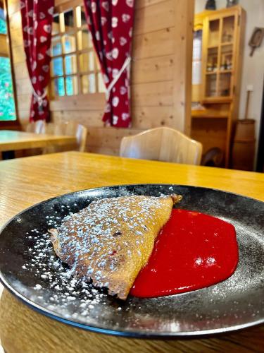 a plate with a piece of food on a table at Hameau des Prodains - Hôtel in Morzine