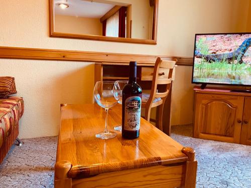 a bottle of wine and a wine glass on a table at Family Hotel Savov in Chepelare