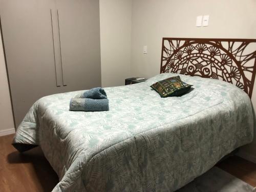 um quarto com uma cama grande e uma cabeceira em madeira em Loft aconchegante e funcional no Campeche em Florianópolis