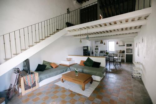 una sala de estar con 2 sofás y una escalera en Charming Loft in the countryside of Althen des Paluds, en Althen-des-Paluds