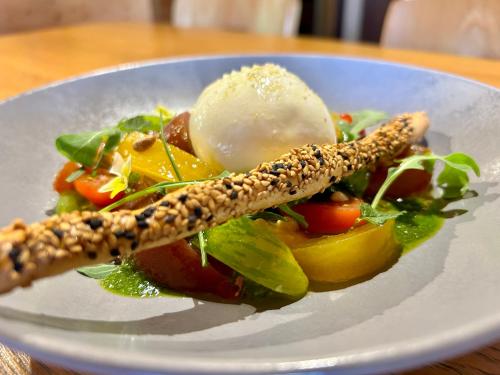 a plate of food with a salad on a table at Hameau des Prodains - Hôtel in Morzine