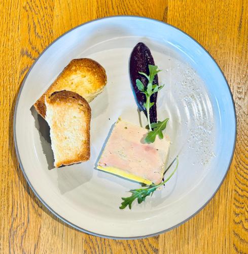 a white plate with two pieces of bread and a knife at Hameau des Prodains - Hôtel in Morzine