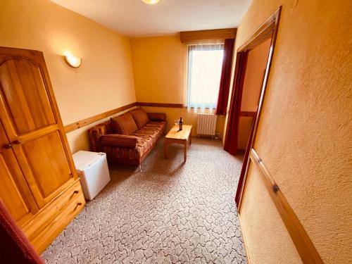 a living room with a couch and a table at Family Hotel Savov in Chepelare