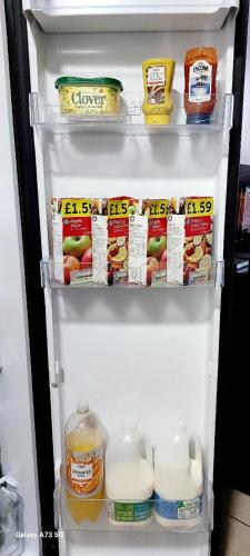 an open refrigerator filled with food and milk at Wilson Lodge in Maidenhead
