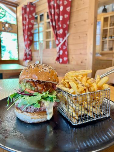 a hamburger and a basket of fries on a table at Hameau des Prodains - Hôtel in Morzine