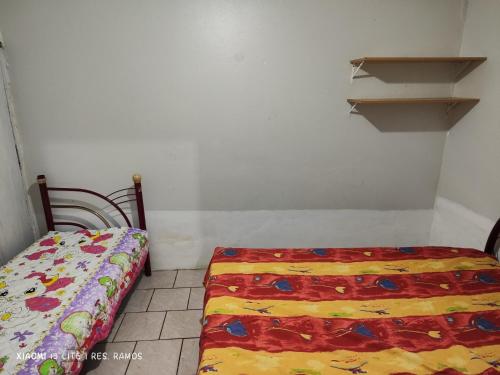 Dormitorio pequeño con cama y estante en Residencial Ramos, en Torres