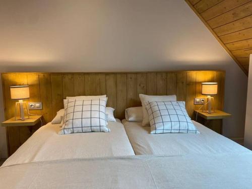 a bedroom with a large bed with two lamps at A 25 m. del Telecabina de Pal in La Massana