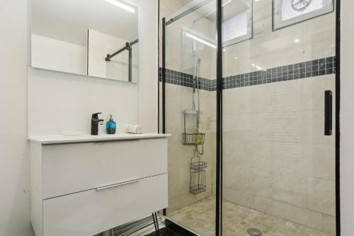 La salle de bains est pourvue d'une douche en verre et d'un lavabo. dans l'établissement Chic and spacious apartement with piano and terrace, à Le Chesnay