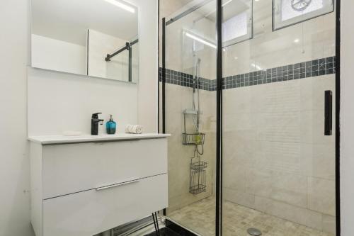 a bathroom with a glass shower and a sink at Chic and spacious apartement with piano and terrace in Le Chesnay
