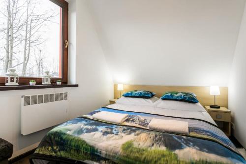 sypialnia z dużym łóżkiem i oknem w obiekcie Rent like home - Strzelców 24C w mieście Kościelisko