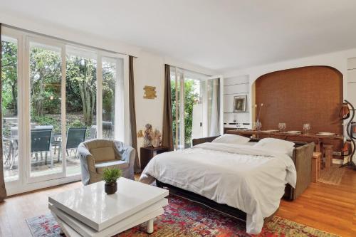 1 dormitorio con 1 cama grande, escritorio y silla en Chic and spacious apartement with piano and terrace, en Le Chesnay