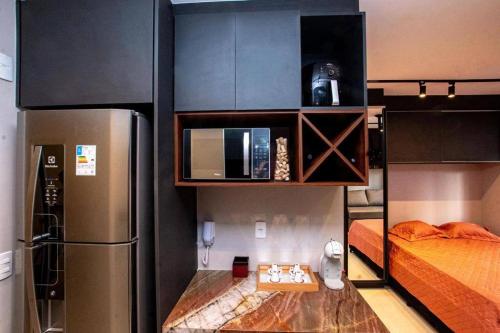 a small room with a refrigerator and a bed at Studio de Luxo de Alta Qualidade in Sao Paulo