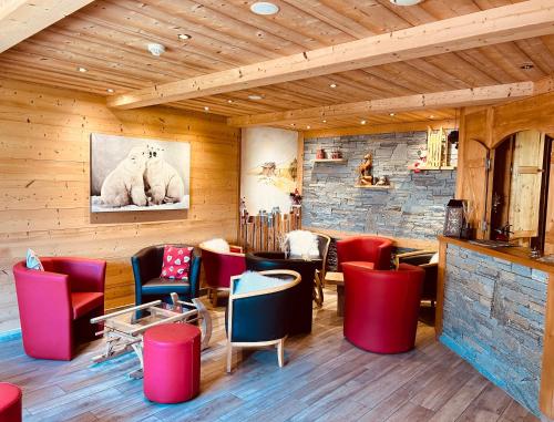 ein Restaurant mit roten und blauen Stühlen und einer Ziegelwand in der Unterkunft Hameau des Prodains - Hôtel in Morzine