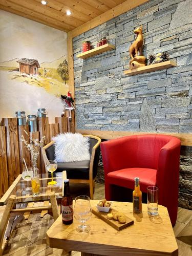 a restaurant with a table and chairs and a stone wall at Hameau des Prodains - Hôtel in Morzine