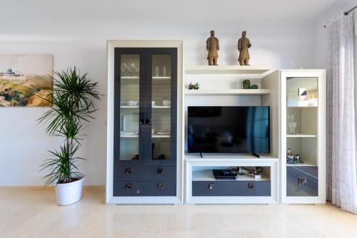 a living room with a tv in a white entertainment center at Neptuno Luxury Apartment in Rincón de la Victoria