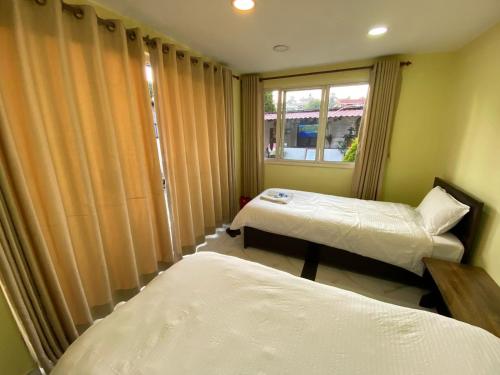 Cette chambre comprend 2 lits et une fenêtre. dans l'établissement Ocean Inn, à Katmandou