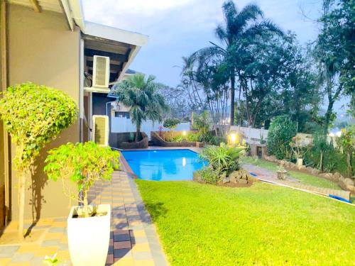 a house with a swimming pool in a yard at Listos Guest House in Empangeni