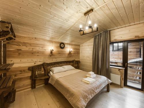 sypialnia z łóżkiem w drewnianym domku w obiekcie Adel Resort w mieście Pławie