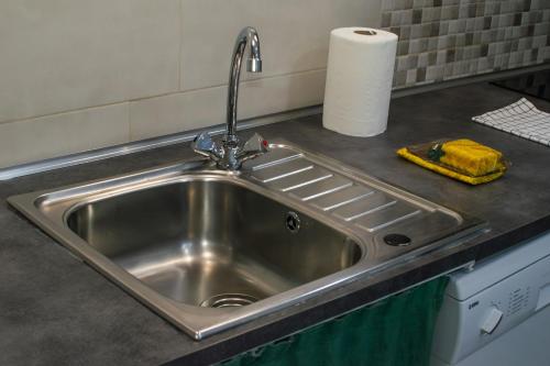 a stainless steel sink in a kitchen with a roll of paper towels at Estudio en el pleno centro de Alicante by Renthas in Alicante