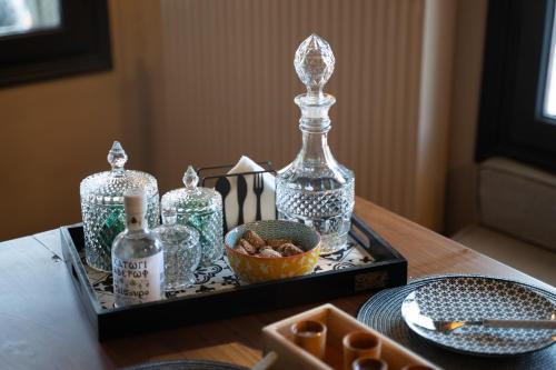 a tray with glass bottles and a bowl of food at Dandy Villas Metsovo-Mezzo-Down Town-Up 5 in Metsovo