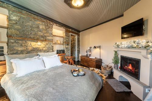 a bedroom with a large bed and a fireplace at Dandy Villas Metsovo in Metsovo