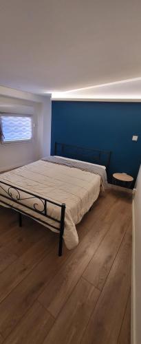 une chambre avec un lit avec un mur bleu dans l'établissement Maison 130m2, terrasse 70 m2 sud, 1à7 Pers, 3 chbres avec TV et clim, à Pierrelatte