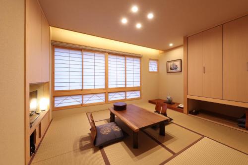 a living room with a table and a large window at Mutsumikan in Gero