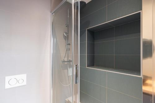 a shower with a glass door in a bathroom at Dify Balcony - Quartier Ainay in Lyon