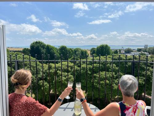two women drinking wine on the balcony of a vineyard at Skyline Oasis in Portsmouth