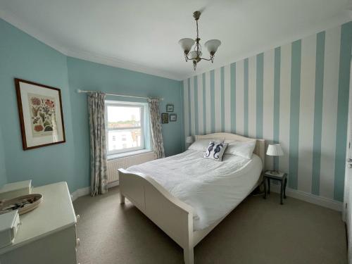 una camera da letto con un letto con pareti blu e una finestra di Skyline Oasis a Portsmouth
