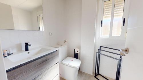 uma casa de banho branca com um lavatório e um WC em Casa Claveles - A Murcia Holiday Rentals Property em Santiago de la Ribera